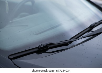 close-up car windshield rain wipers, rainy weather and vehicles concept