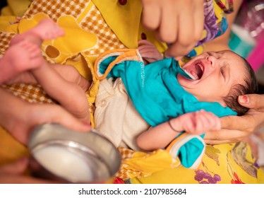 Close-up Of Caring Indian Mother Feeding Milk To Her A Newborn Baby With A Spoon. 