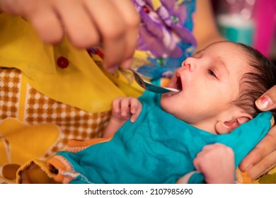 Close-up Of Caring Indian Mother Feeding Milk To Her A Newborn Baby With A Spoon. 