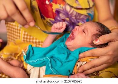 Close-up Of Caring Indian Mother Feeding Milk To Her A Newborn Baby With A Spoon. 