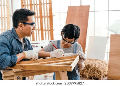 Close-up carpenter hands wearing work gloves draw the cutting line with a pencil on a wooden board. Construction industry, carpentry workshop. Carpenter at work on wooden boards. Carpentry concept. - Powered by Shutterstock