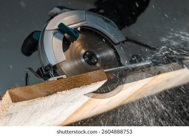 Close-up of a carpenter using a circular saw to cut a large board of wood 