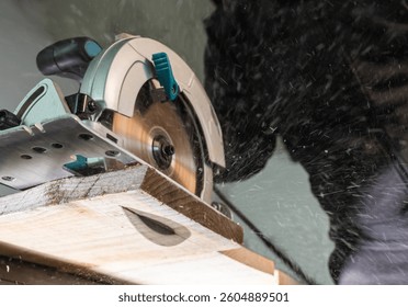 Close-up of a carpenter using a circular saw to cut a large board of wood 