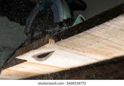 Close-up of a carpenter using a circular saw to cut a large board of wood 