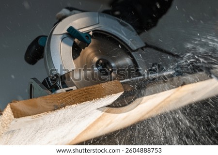 Close-up of a carpenter using a circular saw to cut a large board of wood 