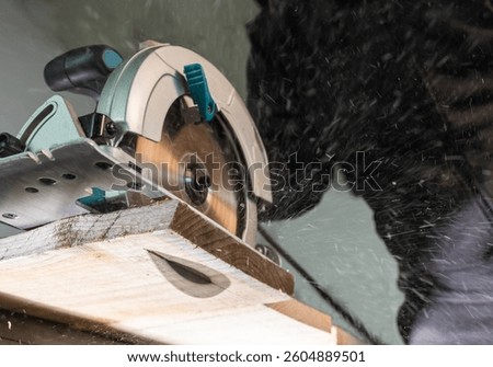 Close-up of a carpenter using a circular saw to cut a large board of wood 