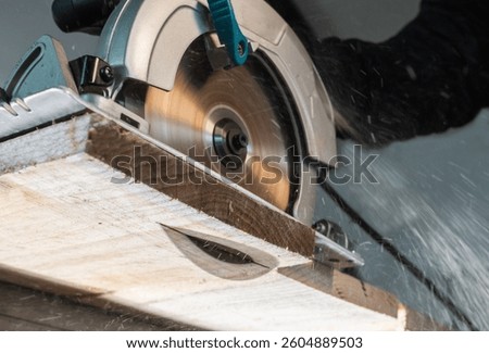 Close-up of a carpenter using a circular saw to cut a large board of wood 