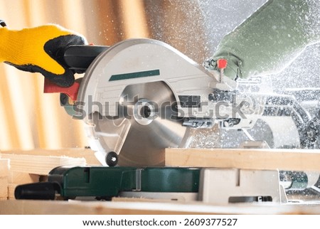 Close-up of a carpenter using a circular saw to cut a large board of wood 