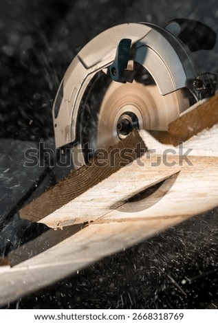 Close-up of a carpenter using a circular saw to cut a large board of wood 