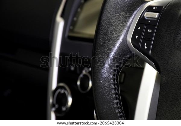 Close-up of the car\'s Music control buttons on the\
steering wheel.