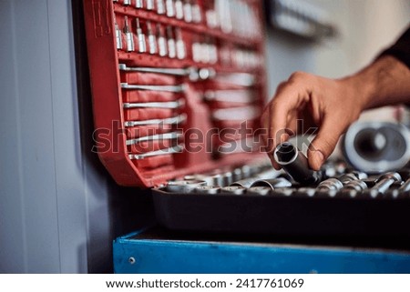 Close-up of a case with tools, mechanic taking a lug bolt tool.