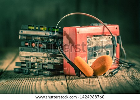 Closeup of cassette tape, red walkman and headphones