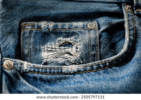 Close-up casual classic style denim blue jeans pocket on worn jeans.