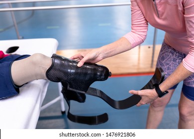 Close-up of Caucasian active senior female trainer wearing prosthetic leg to disabled Caucasian man in sports center. Sports Rehab Centre with physiotherapists and patients working together towards - Powered by Shutterstock