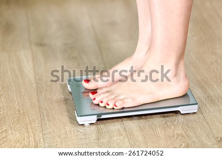Close-up Caucasian legs standing on the floor scale
