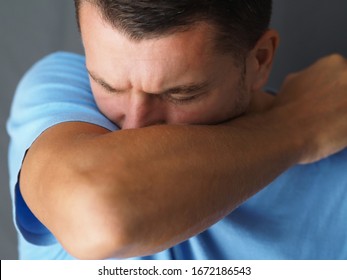 Close-up. Caucasian male coughs in his elbow. Correct sneezing. Concept of stop spread of the virus. - Shutterstock ID 1672186543