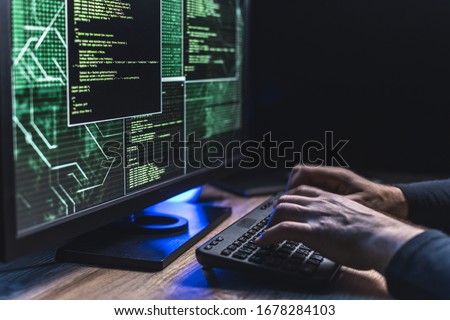 Close-up of Caucasian man hands typing data on a keyboard,seen on a computer monitor