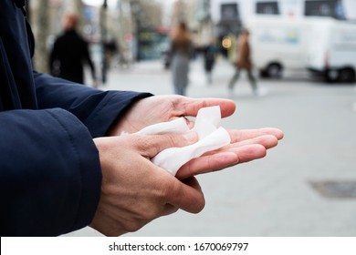 Closeup Of A Caucasian Man On The Street Disinfecting His Hands With A Wet Wipe