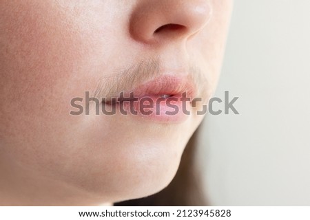 A close-up of caucasian woman's face with a mustache over her upper lip. The concept of hair removal and depilation.