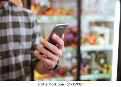 Closeup Of Cell Phone Used By Man In Grocery Shop