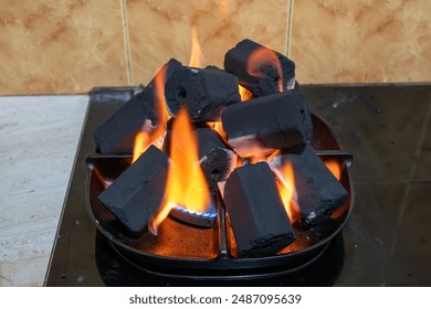 Close-up of charcoal briquettes glowing with intense heat in a grill, ready for cooking. This image captures the essence of outdoor grilling and the anticipation of delicious food.