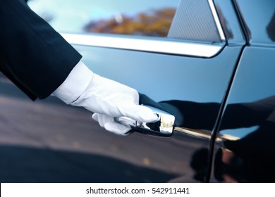 Closeup of chauffeur opening car door