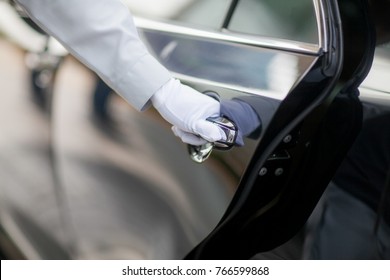 Closeup of Chauffeur opening car door with glove - Shutterstock ID 766599868