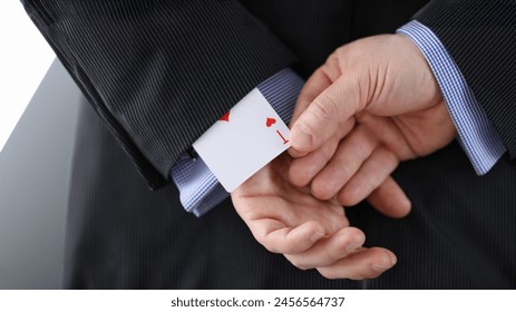 Close-up of cheater hands pulling ace card out of sleeve with crossed arms behind. Gamer with strong addiction to games. Bribe casino and dishonesty concept
