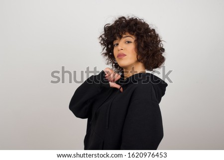 Closeup of cheerful beautiful European young woman looks joyful, satisfied and confident, points at herself with thumb, isolated over studio background.