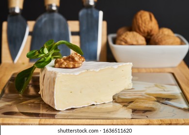 Close-up of cheese and walnuts on wood cheese board