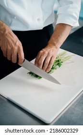 Close-up Of A Chef Finely Chopping Herbs In A Professional Kitchen