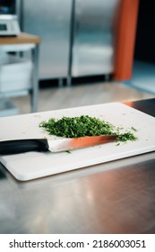 Close-up Of A Chef Finely Chopping Herbs In A Professional Kitchen