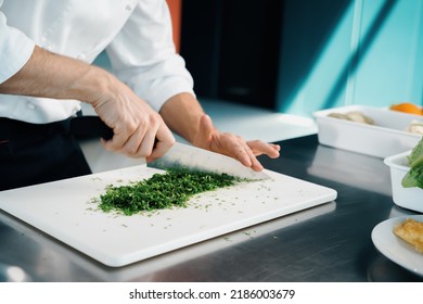 Close-up Of A Chef Finely Chopping Herbs In A Professional Kitchen