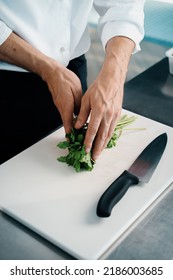 Close-up Of A Chef Finely Chopping Herbs In A Professional Kitchen