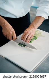 Close-up Of A Chef Finely Chopping Herbs In A Professional Kitchen