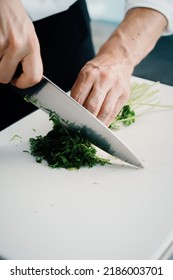 Close-up Of A Chef Finely Chopping Herbs In A Professional Kitchen