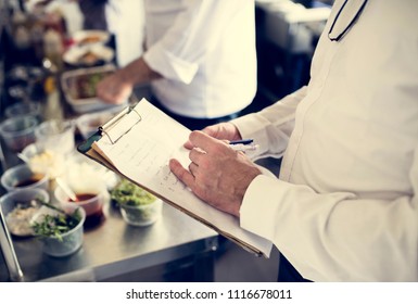 Closeup of chef hand checking menu list - Powered by Shutterstock