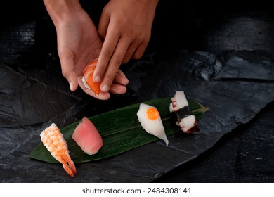 Closeup of chef hands preparing Japanese food, Japanese-style chef uses his hands to make various toppings of sushi, view from above - Powered by Shutterstock