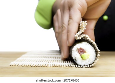 closeup of chef hands rolling up sushi - focus on the roll - Powered by Shutterstock