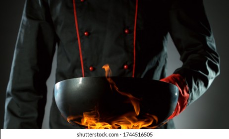 Closeup Of Chef Holding Empty Wok Pan In Fire, Ready To Prepare For Cooking.