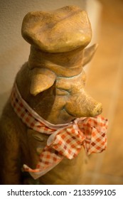 A closeup of a chef pig sculpture on a blurred background