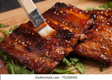 Close-up Chef Spreading Sauce Bbq On Ribs With Brush.