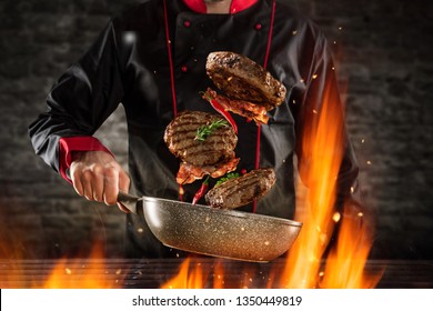 Closeup Of Chef Throwing Hamburger Steaks Into The Air. Concept Of Food Preparation, Grill And Barbecue