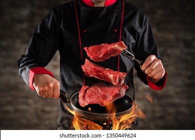 Closeup Of Chef Throwing Raw Beef Steaks Into The Air. Concept Of Food Preparation, Grill And Barbecue