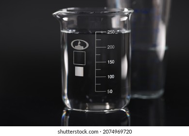 Closeup Of Chemical Beaker With Water On Black Background