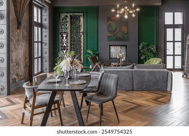Close-up of a chic luxury dining table in a dark brutal interior in a historical style in a mansion with panoramic windows. grey-green walls and brown parquet