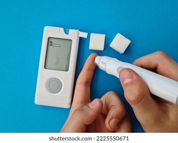 Closeup Of Child Hand Checking Blood Sugar Levels With Glucometer. Diabetes And Blood Control