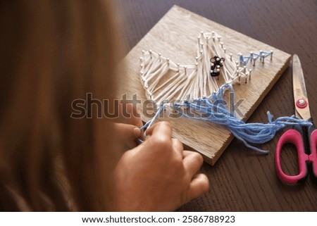 Close-up of a child hands creating string art. Enhancing concentration, creativity, and sensory skills.