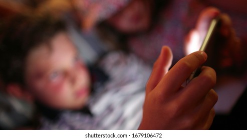 Closeup Of Child Holding Tablet Tech Device At Night, Kids Watching Movie