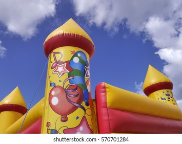 Closeup Of Children's Bouncy Castle Against Blue Cloudy Sky.